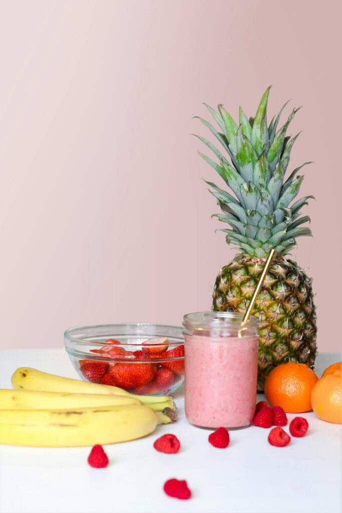 A vibrant smoothie with pineapple, banana, and berries, showcasing healthy freshness.